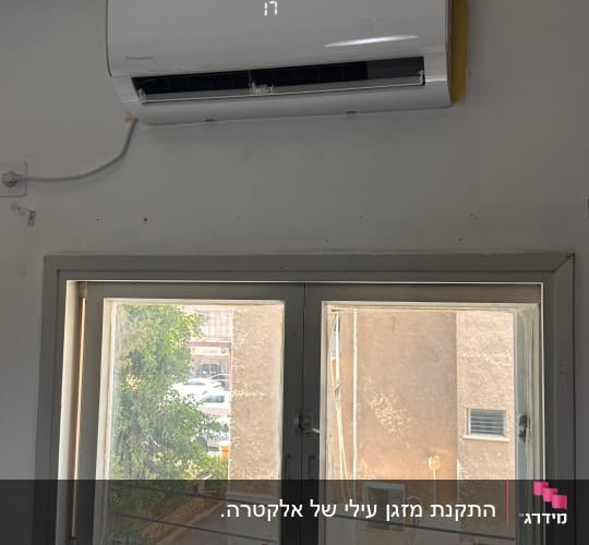 מזגן מותקן על קיר מעל חלון